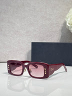 Dior rectangular sunglasses with pink-tinted lenses, burgundy frame, gold star temple detail