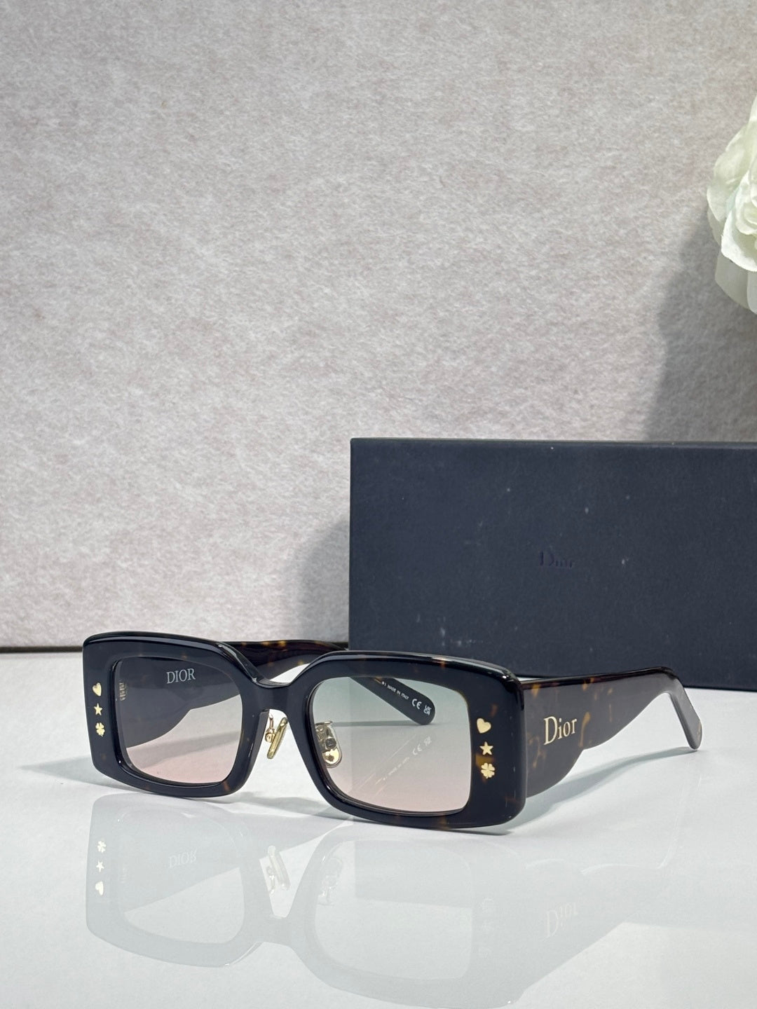 Dior rectangular sunglasses with dark lenses, navy frame, gold star motifs on temples