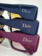 Stacked Dior eyeglass frames with dark lenses and burgundy frame, plus logo cases