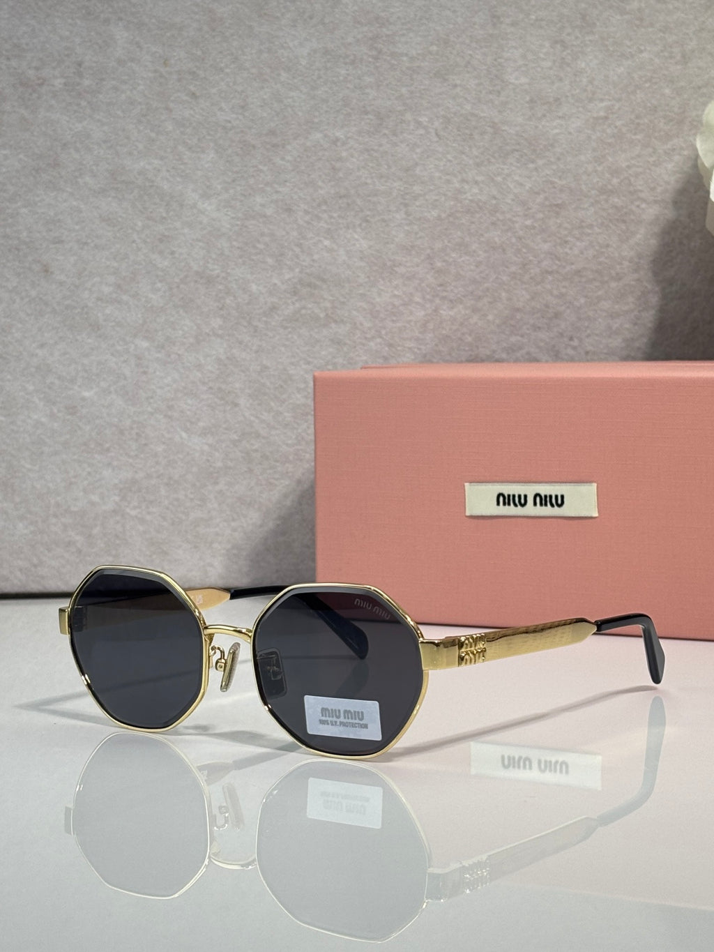 MiuMiu round sunglasses with gold frame and dark gray tinted lenses