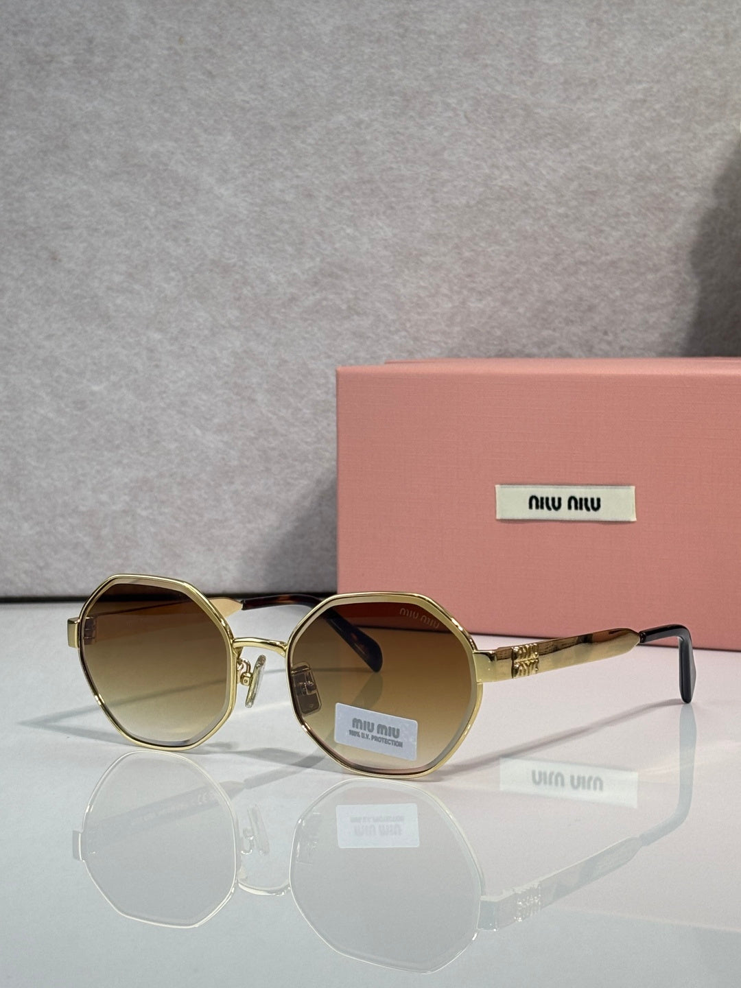 MiuMiu round sunglasses with gold frame and brown tinted lenses