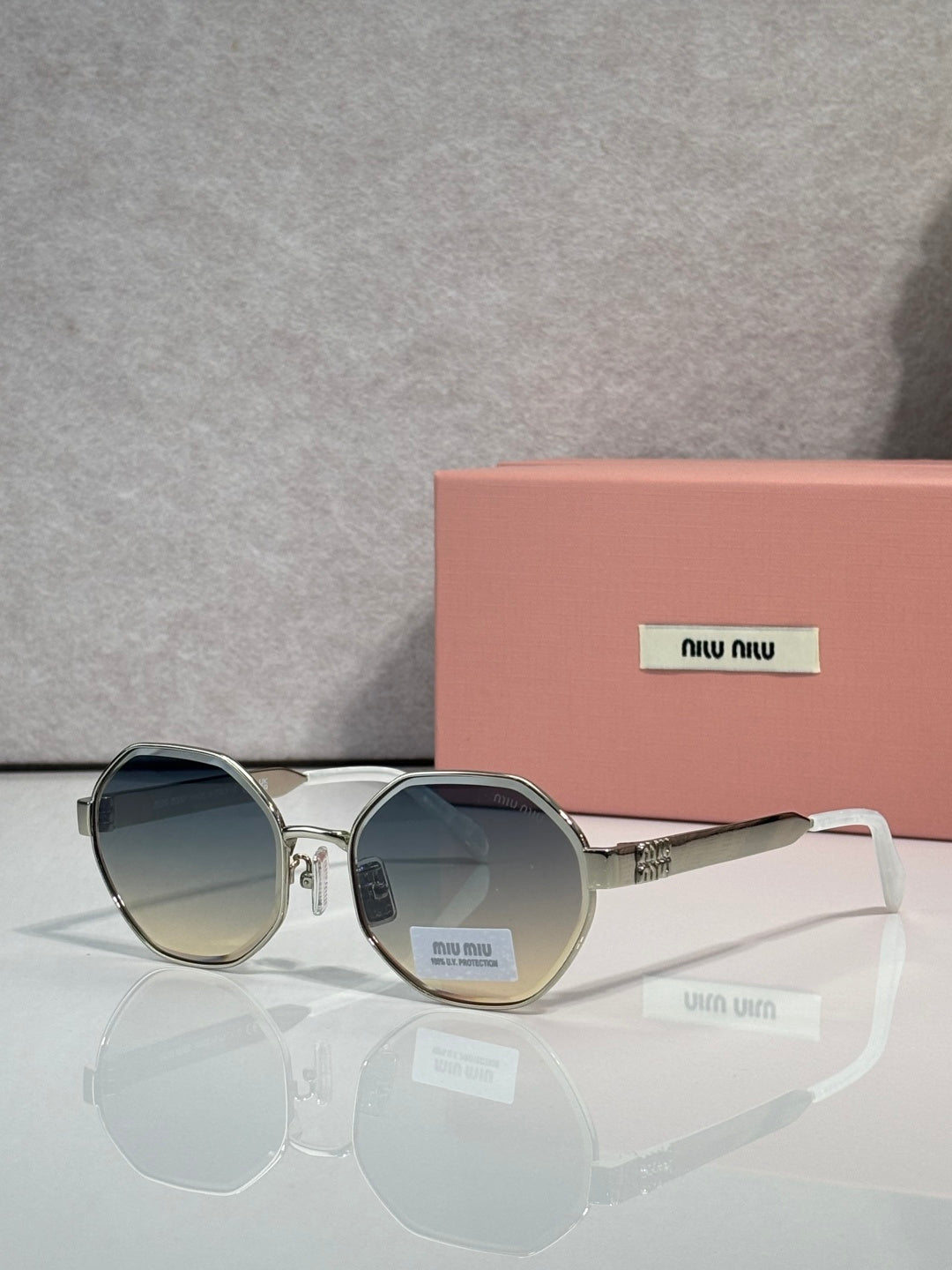 MiuMiu round sunglasses with gray tinted lenses and silver frame