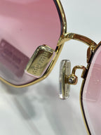 MiuMiu sunglasses temple close-up with gold hinge and engraved logo
