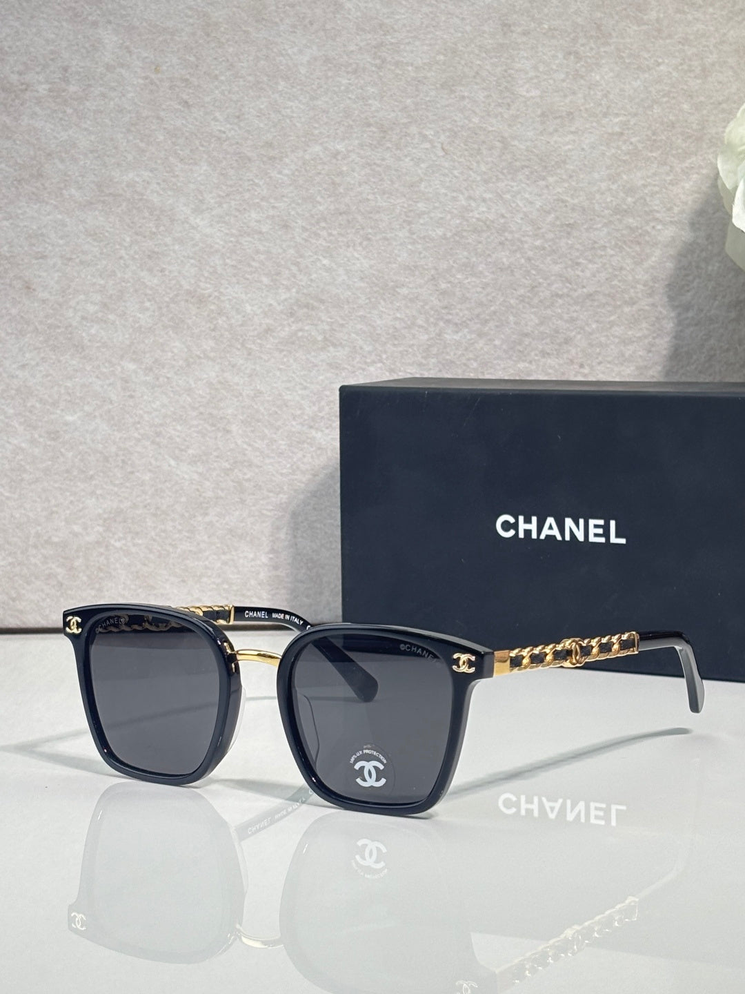 Chanel dark blue square eyeglasses with gold-tone chain detail on temples