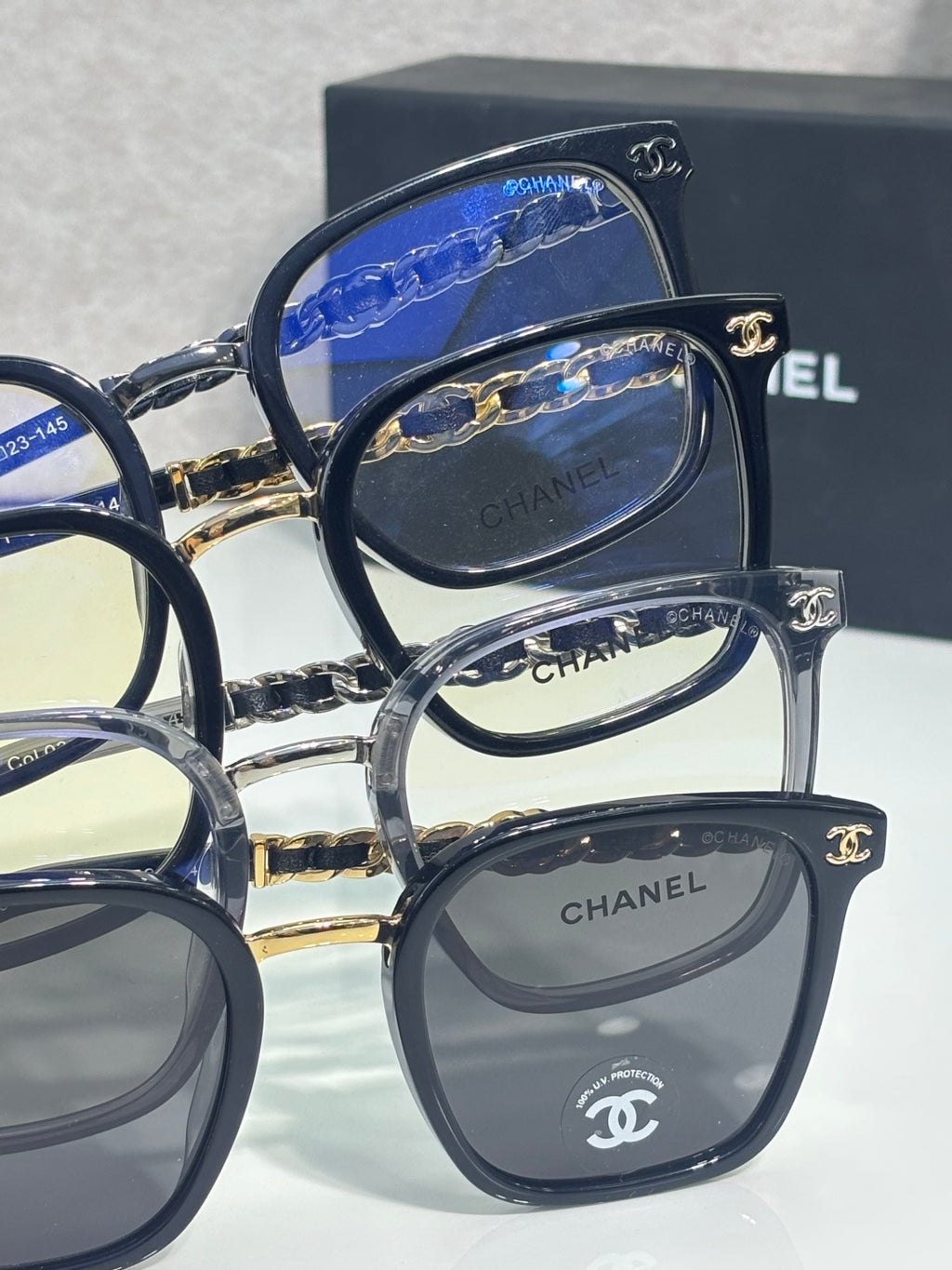 Chanel eyeglasses side-by-side with dark frames and gold chain temple details
