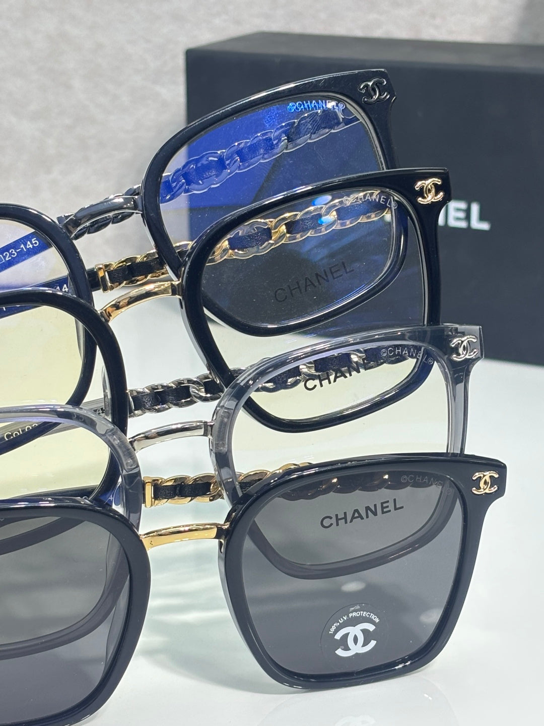 Chanel eyeglasses side-by-side with dark frames and gold chain temple details