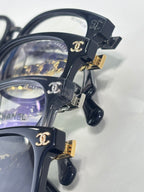Chanel dark blue eyeglasses close-up with gold buckle and chain temple accents