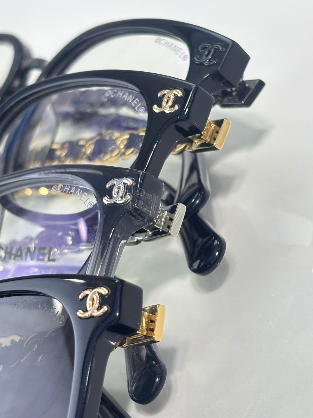 Chanel dark blue eyeglasses close-up with gold buckle and chain temple accents