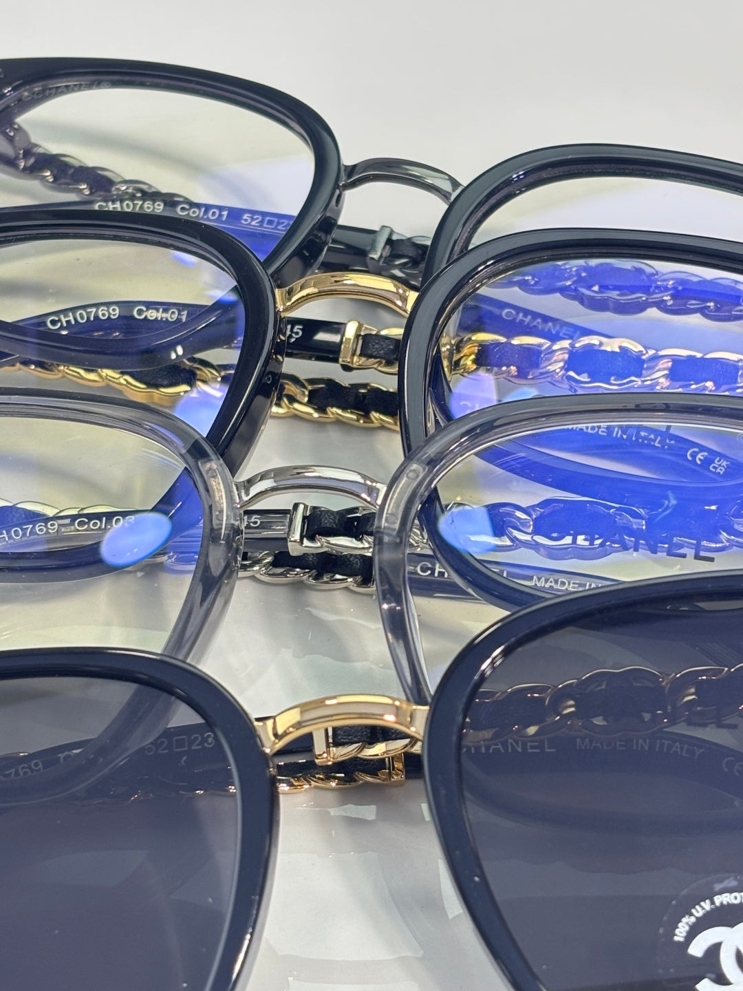 Chanel eyeglasses close-up: stacked dark frames with gold chain temple details