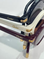 Stacked eyeglasses with black, cream, and burgundy frames and gold-tone accents