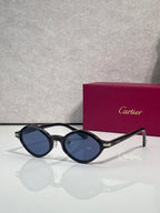 Cartier round sunglasses, dark frames with blue lenses, gold accents at the temples