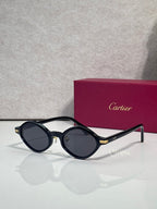 Cartier round sunglasses, black frames, dark tinted lenses, gold accents on temples