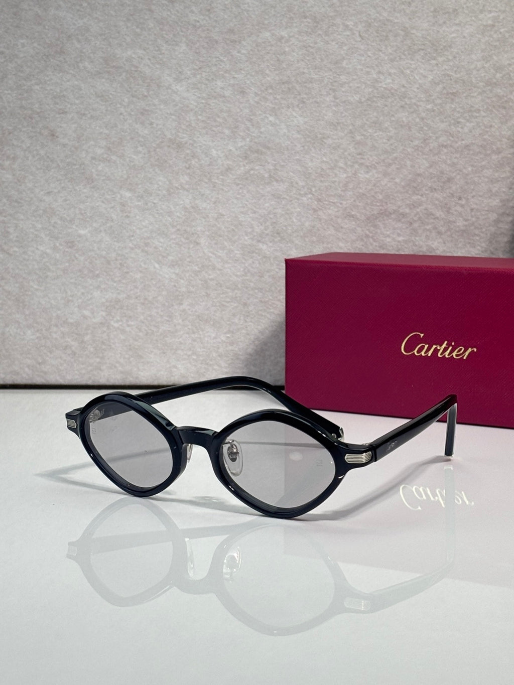 Cartier round sunglasses, black frames, clear lenses, gold detail on temple arms