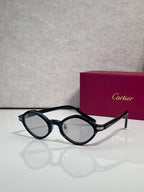 Cartier round sunglasses, black frames, clear lenses, gold detail on temple arms