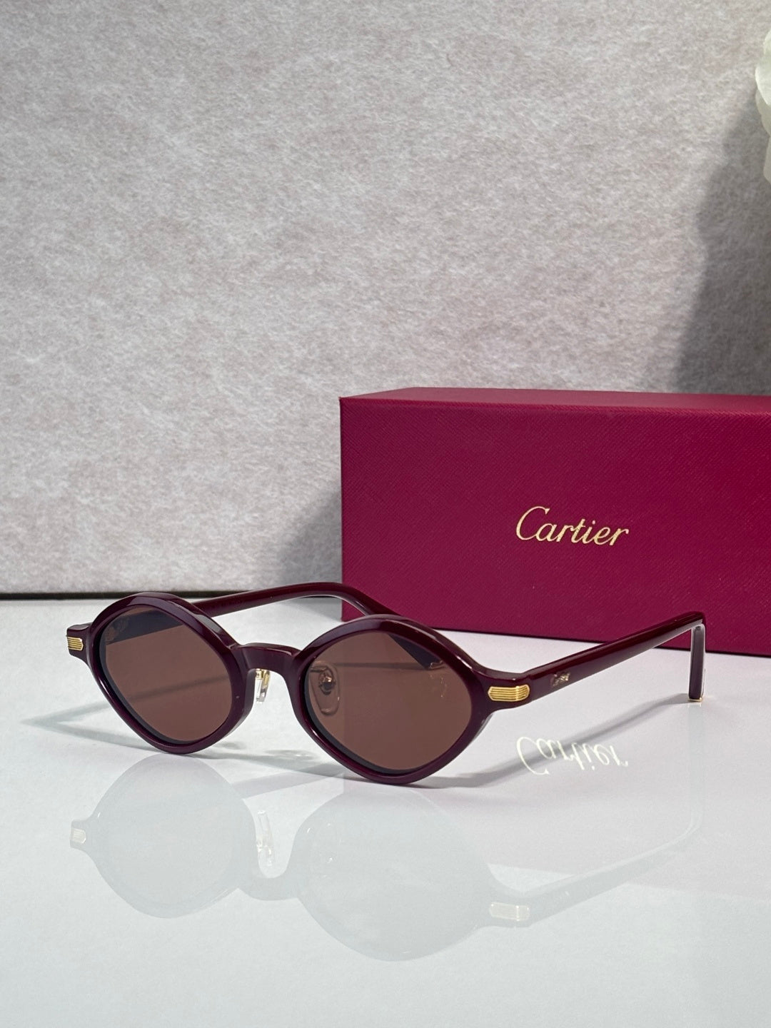 Cartier round sunglasses, burgundy frames, brown tinted lenses, gold detail at temples
