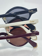 Cartier sunglasses, angled view of navy, cream, and burgundy frames with gold hinges