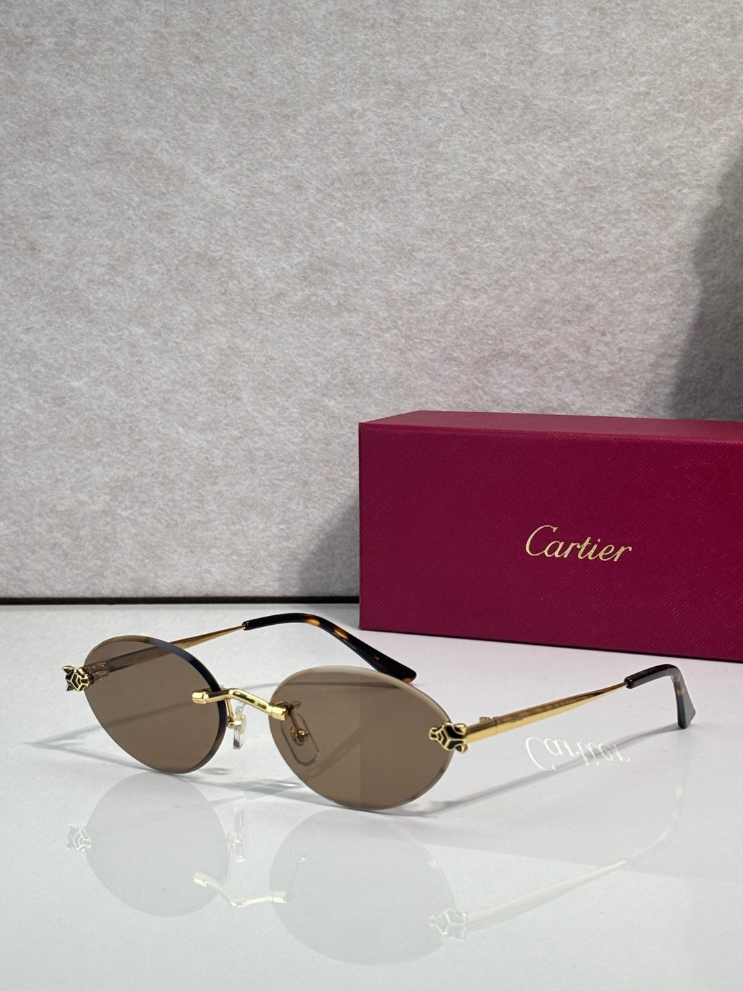 Brown-tinted round sunglasses with gold accents and black temples