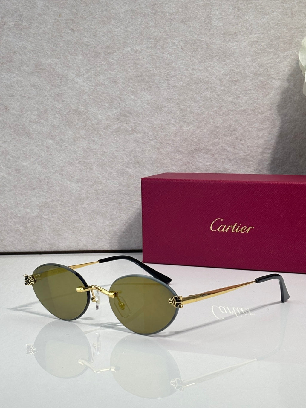 Green-tinted round sunglasses with gold accents and black temples