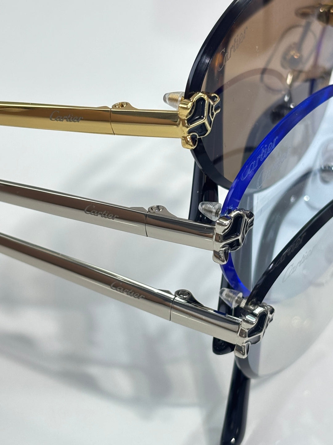 Eyeglasses close-up showing metal hinge, blue accent, and clear lenses