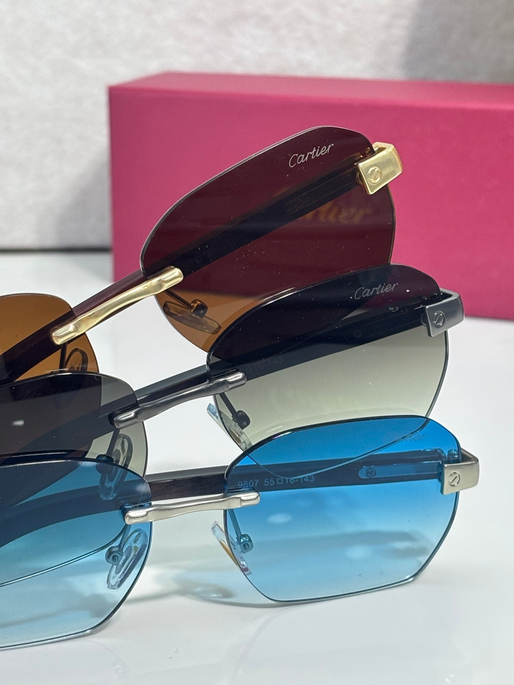 Cartier sunglasses stacked angled view with brown and blue lenses, gold-tone frame