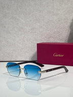 Cartier sunglasses with light blue lenses, dark frame, gold-tone accents