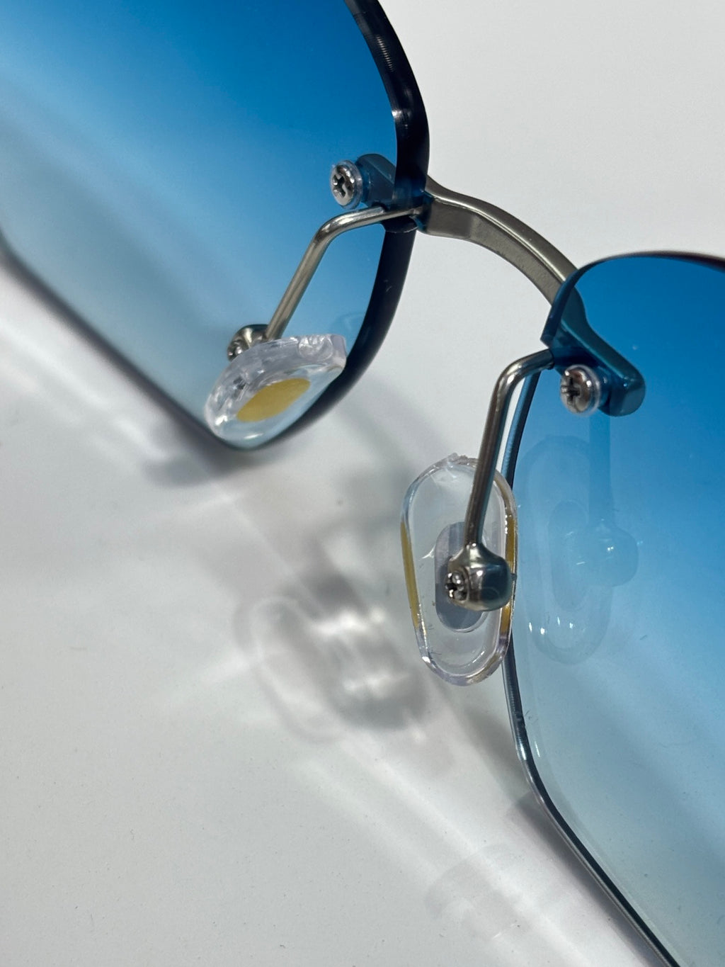 Cartier sunglasses close-up of blue lens and metal hinge with clear detail