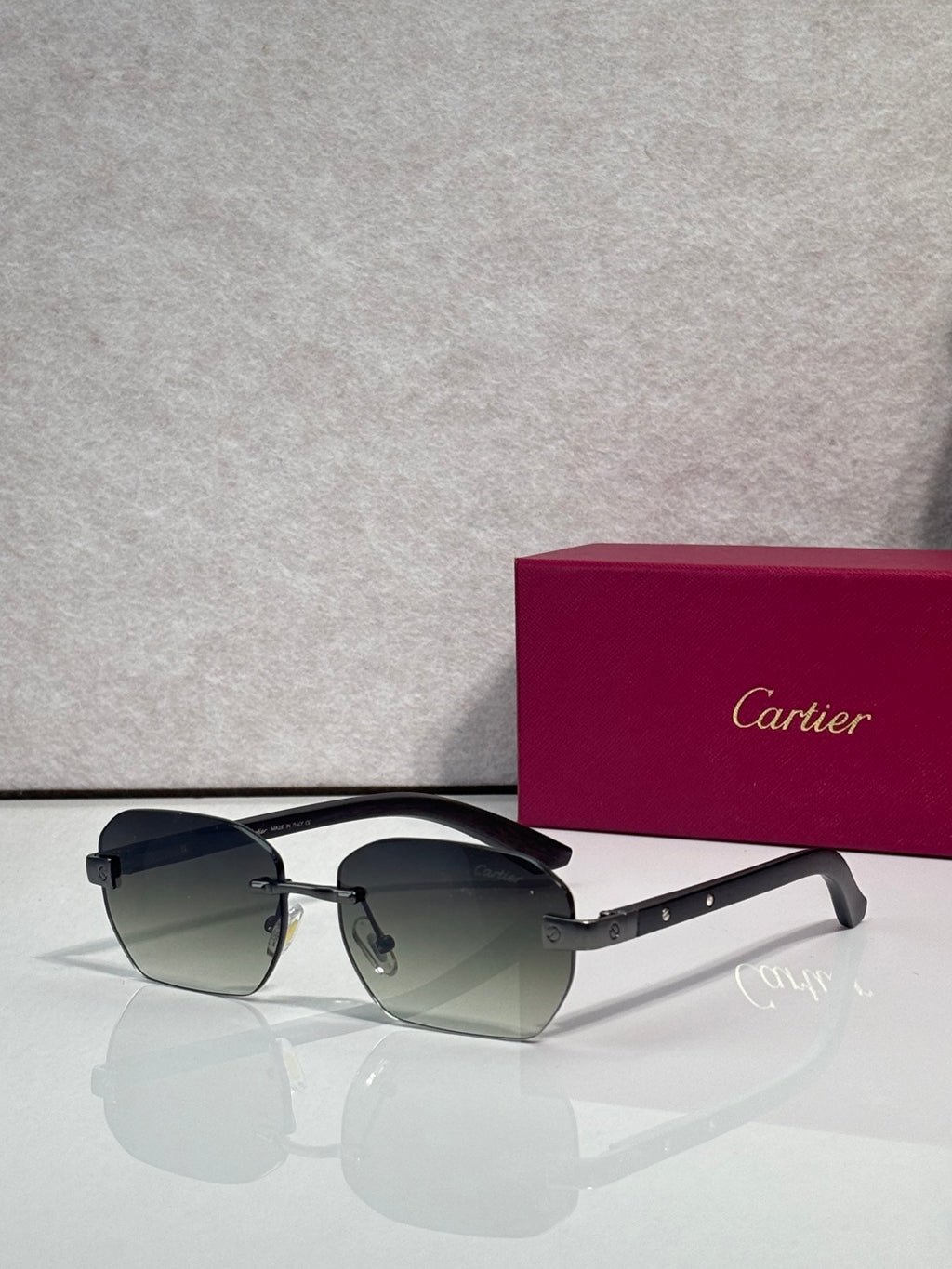 Cartier sunglasses with dark gray-green lenses, black frame and gold accents