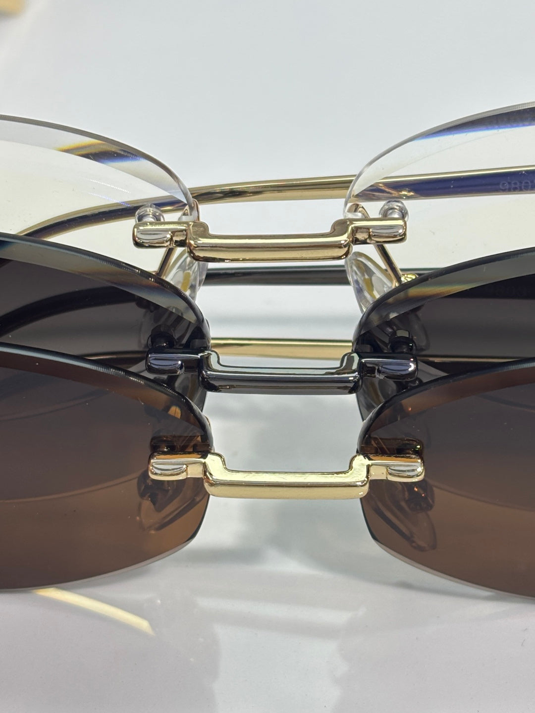 Cartier sunglasses close-up of gold bridge and dark lenses, metal hinge details