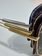 Louis Vuitton sunglasses close-up of gold-tone temple hinge and engraved arm lettering.