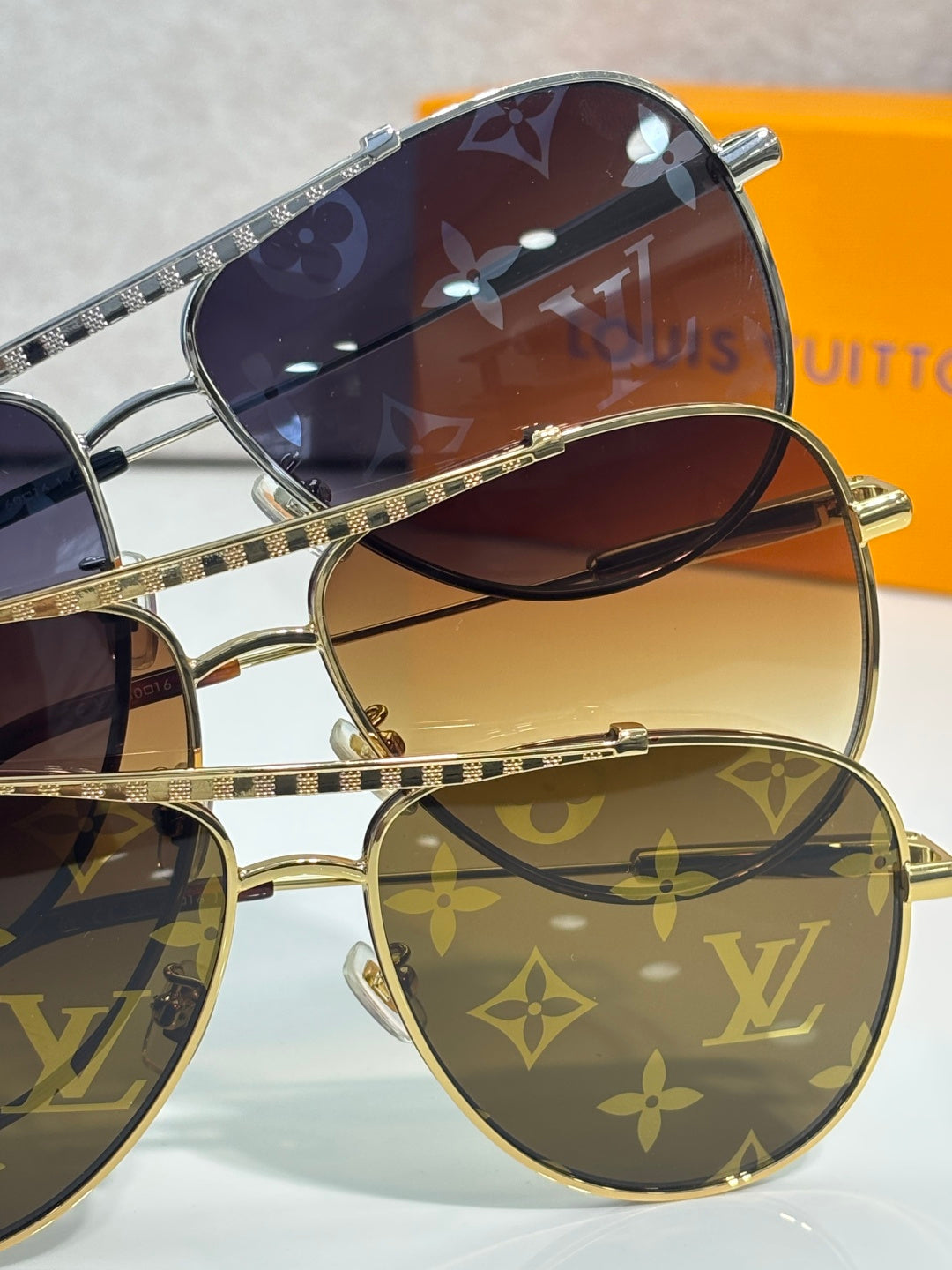 Louis Vuitton sunglasses set with monogram frames and dark to amber gradient lenses.