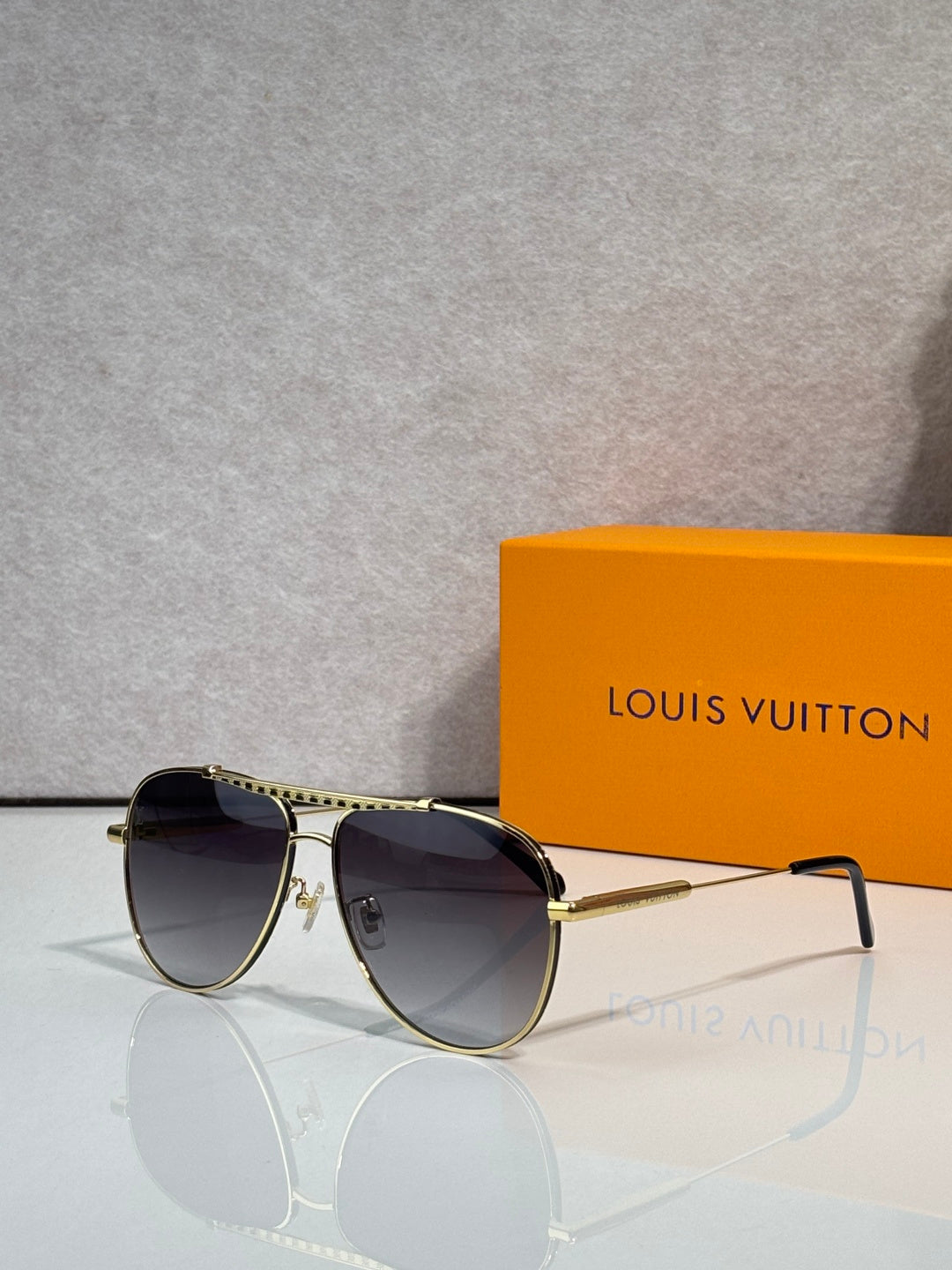 Louis Vuitton sunglasses with dark lenses, gold-tone frames and thin metal arms.