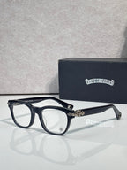 Eyeglasses with dark blue frames and clear lenses, gold accents at the hinge and bridge