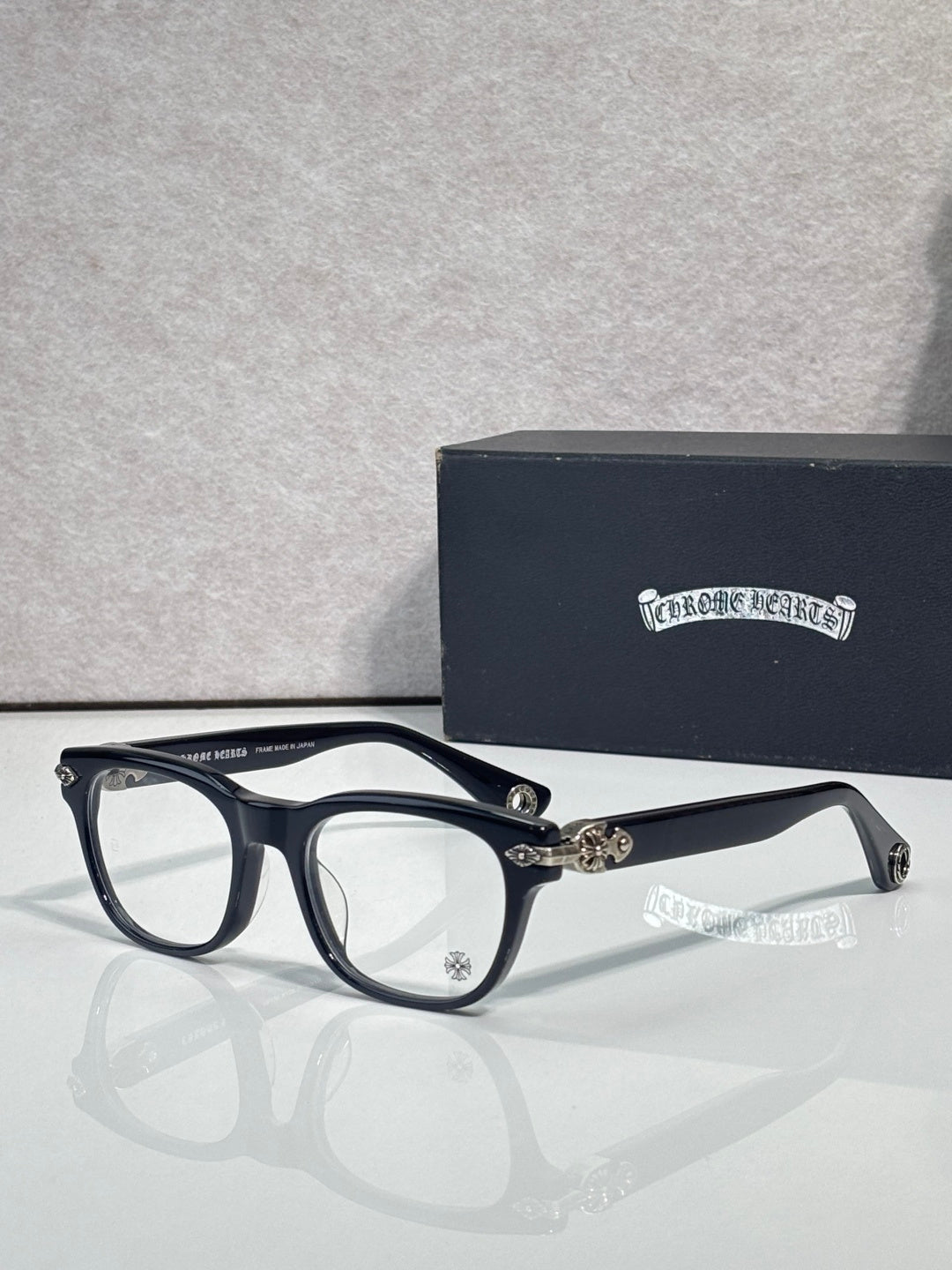 Eyeglasses with dark blue frames and clear lenses, gold accents at the hinge and bridge