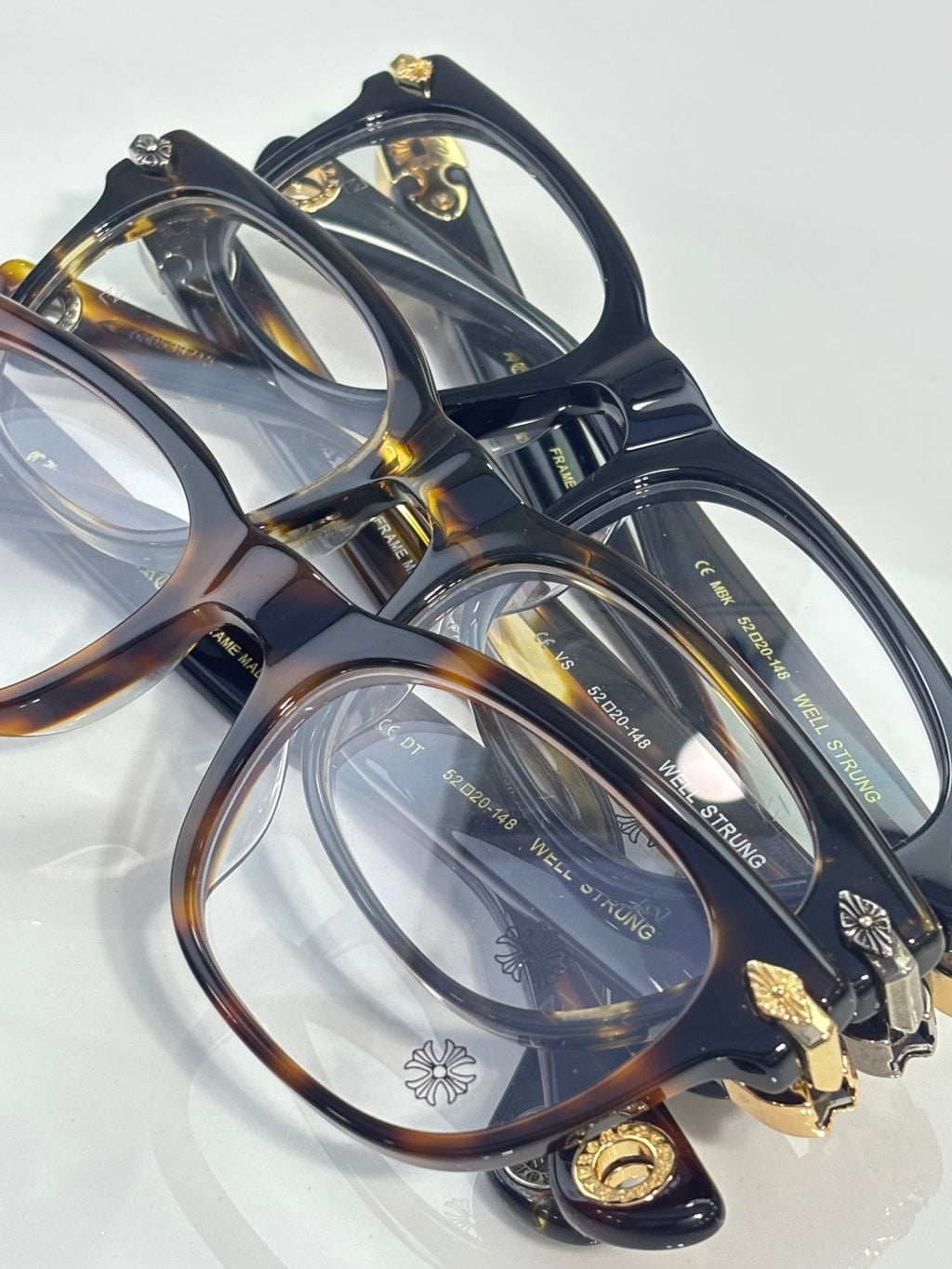 Eyeglasses pair, dark and tortoiseshell frames with clear lenses and gold decorative hinges