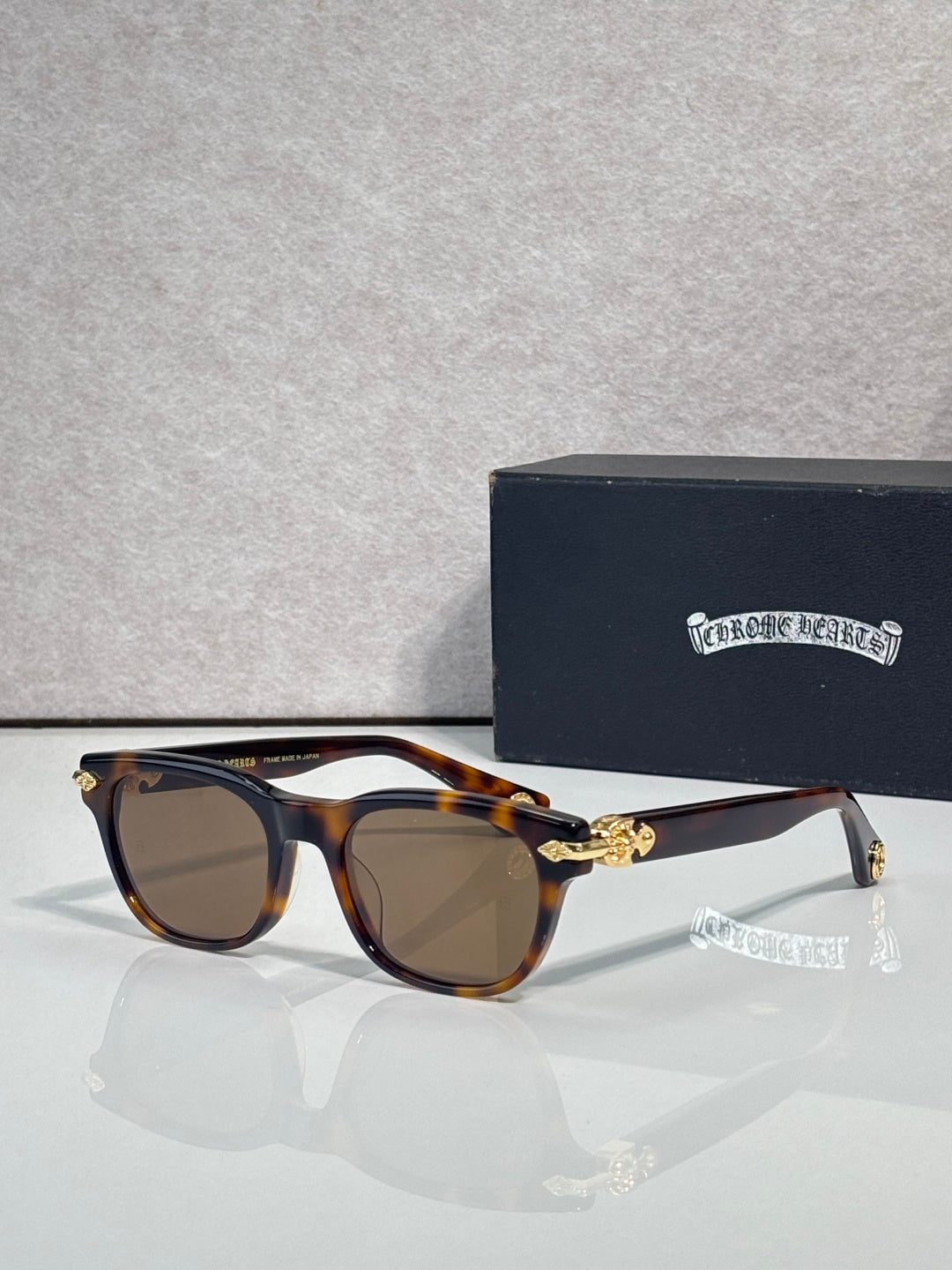 Dark tortoiseshell sunglasses with brown lenses and gold-tone temple centerpiece