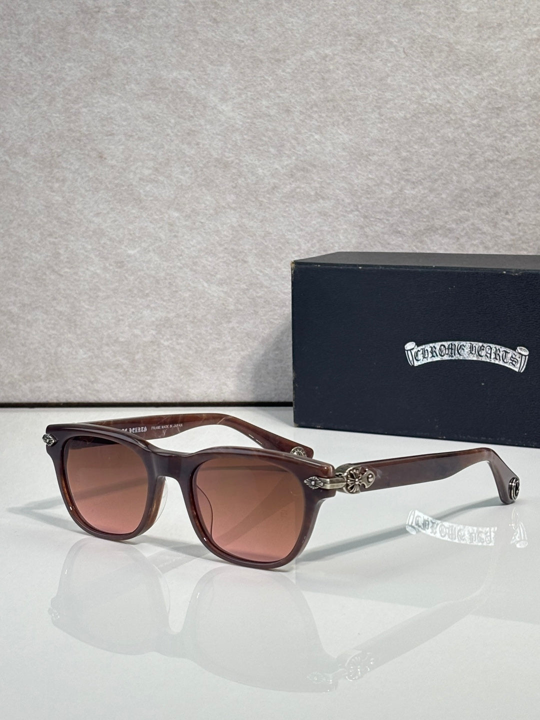 Brown sunglasses with tinted lenses and ornate metal accents on the temples