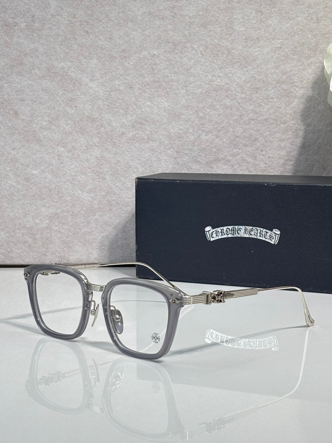 Silver-toned rectangular eyeglasses with clear lenses and metal bridge detail