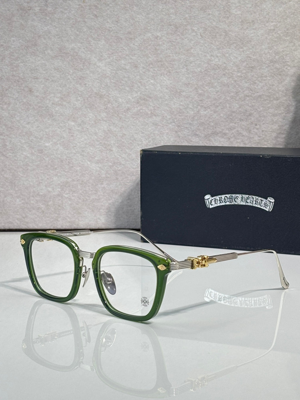 Green eyeglasses with rectangular clear lenses and gold-toned hinge accents