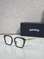 Black and gold eyeglasses with rectangular clear lenses and ornate temple hardware