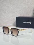 Square sunglasses with dark lenses, black frame, gold temple details, chrome trim