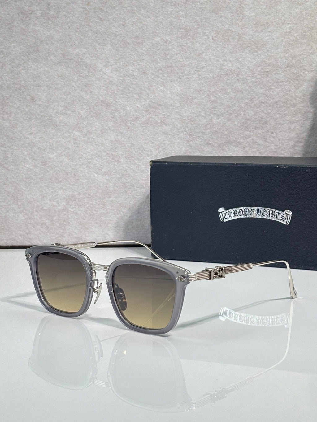 Round-corner square sunglasses with tan lenses, gray frame, gold hinge details, chrome trim
