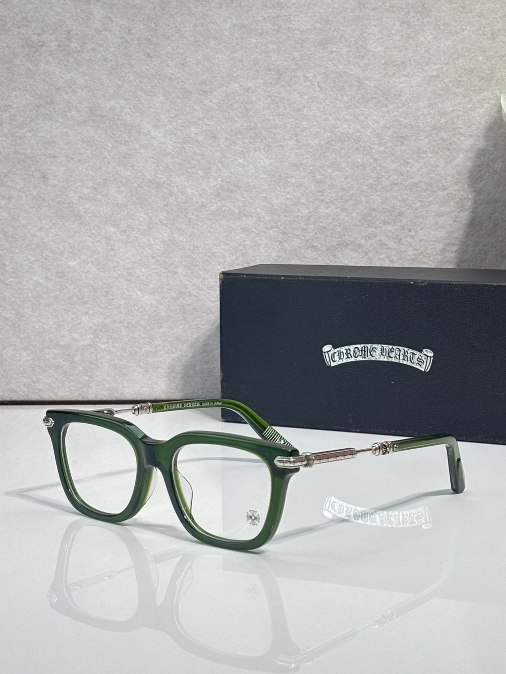 Green eyeglasses with gold metal temples and rectangular lenses