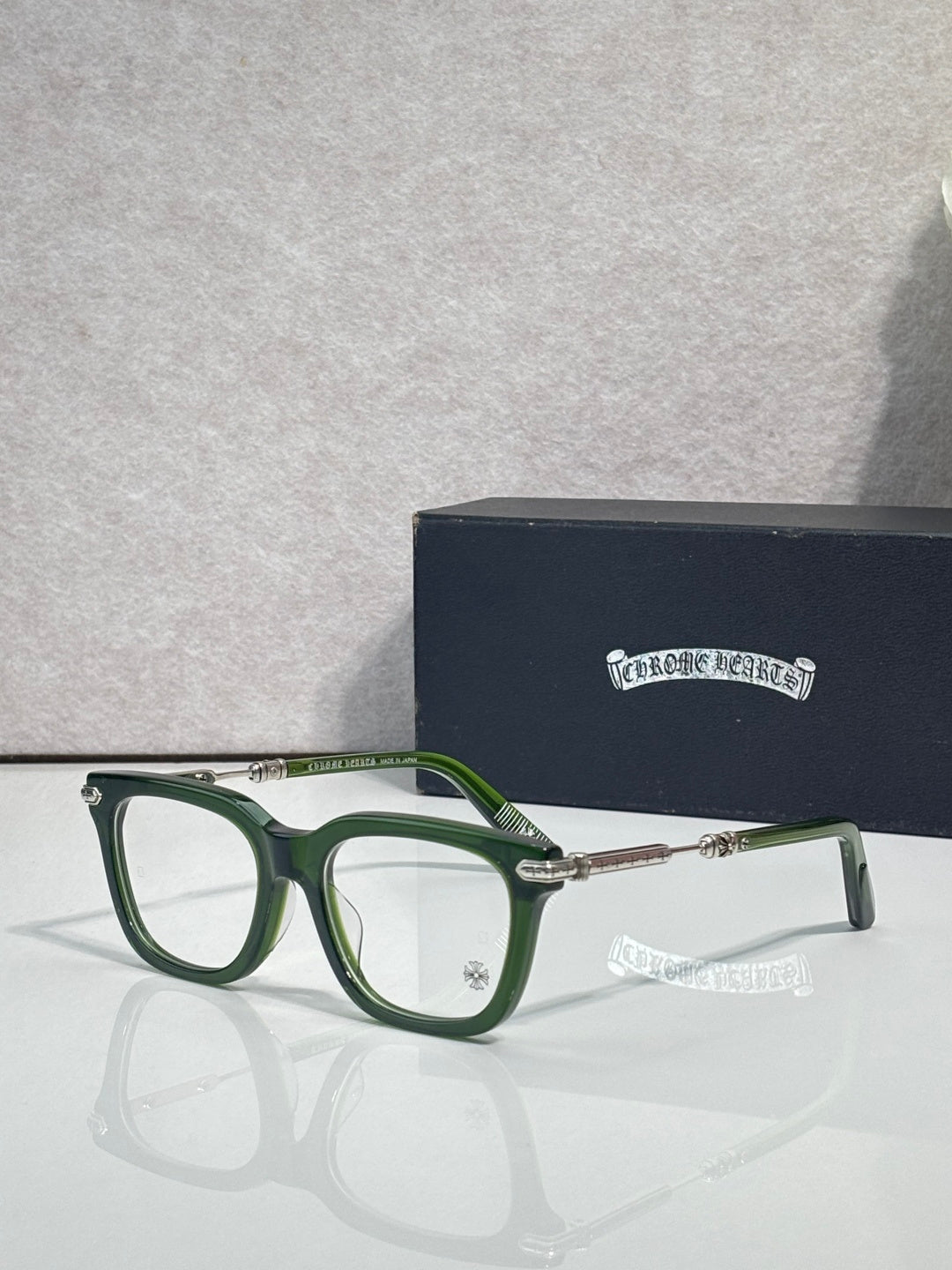 Green eyeglasses with gold metal temples and rectangular lenses