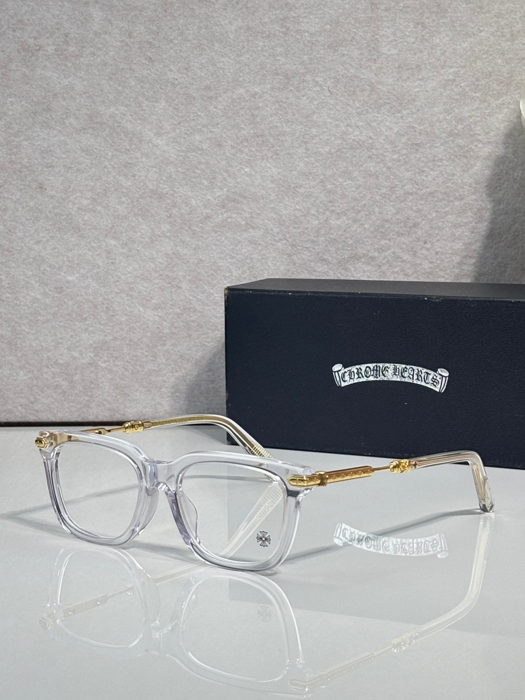Clear eyeglasses with gold metal temples and rectangular frames