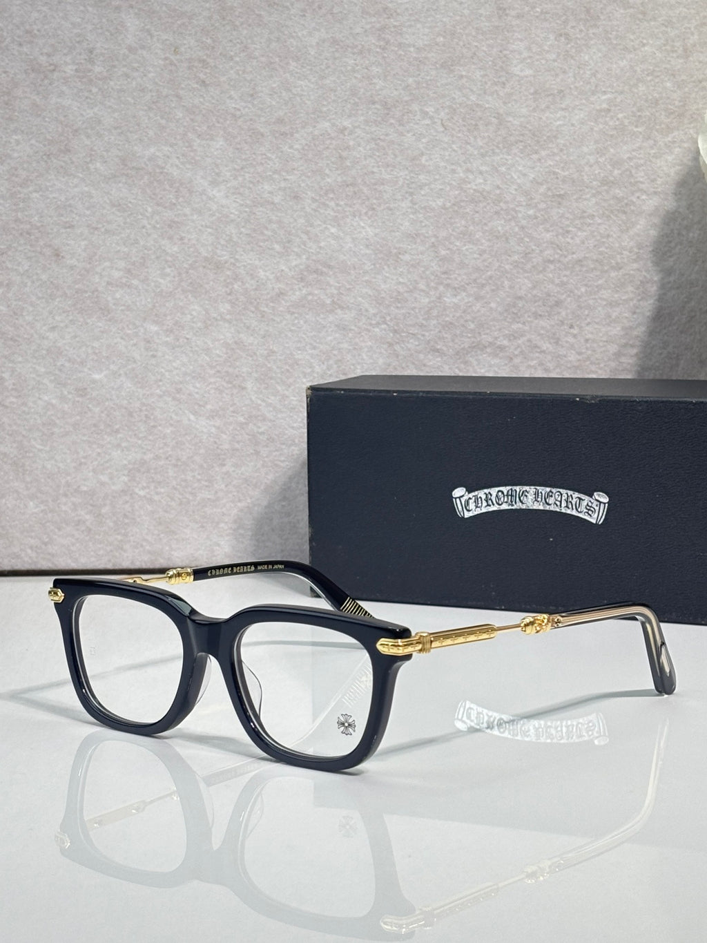 Dark eyeglasses with gold metal temples and rectangular frames