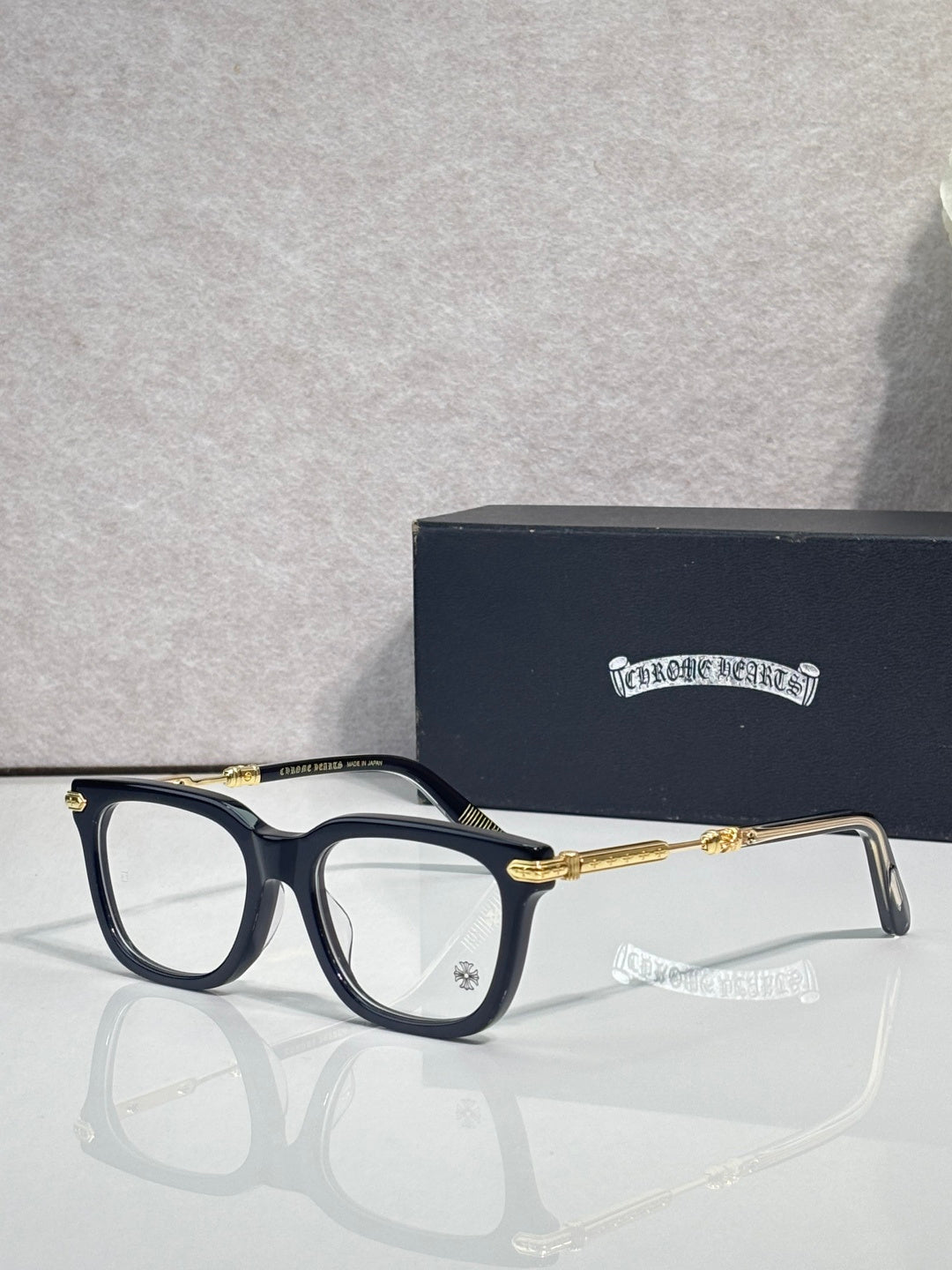 Dark eyeglasses with gold metal temples and rectangular frames