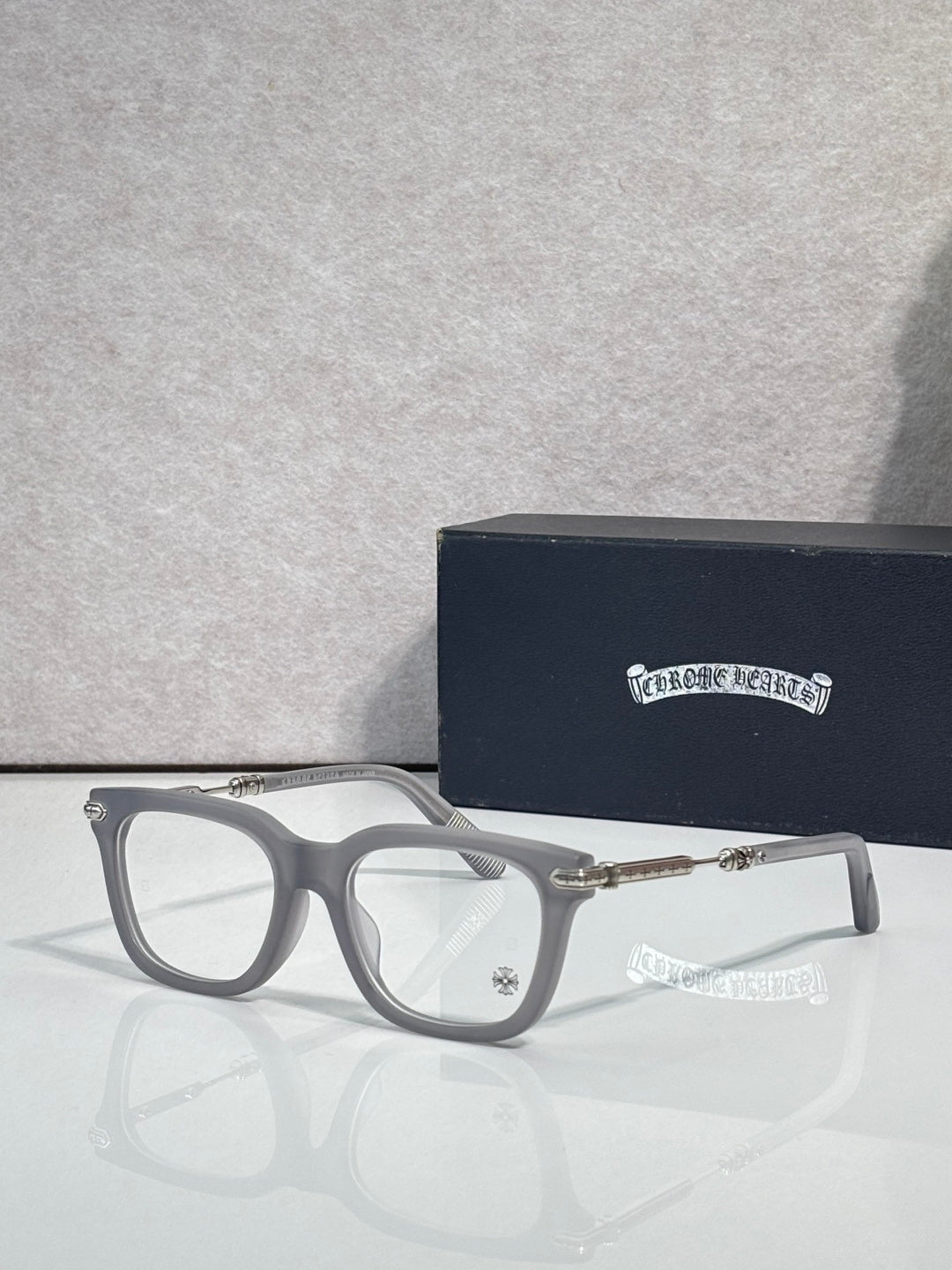Light gray eyeglasses with gold metal temples and rectangular lenses