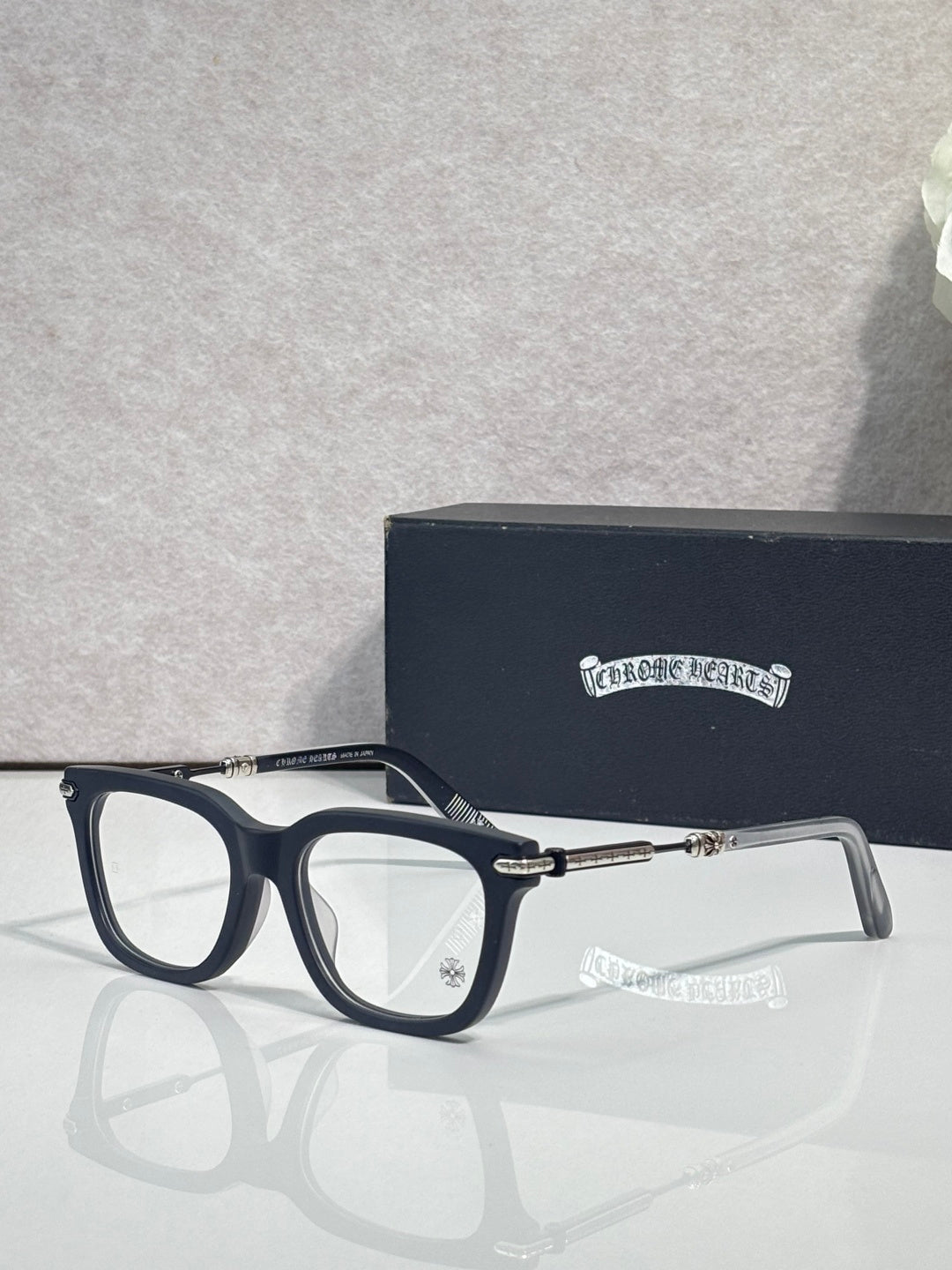 Dark eyeglasses with gold metal temples and rectangular lenses