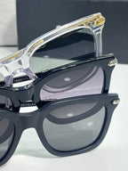 Glasses close-up: dark and clear frames with gold and silver hinges