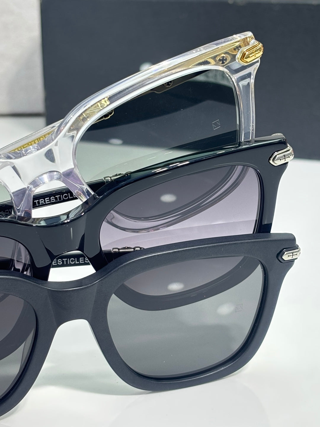 Glasses close-up: dark and clear frames with gold and silver hinges